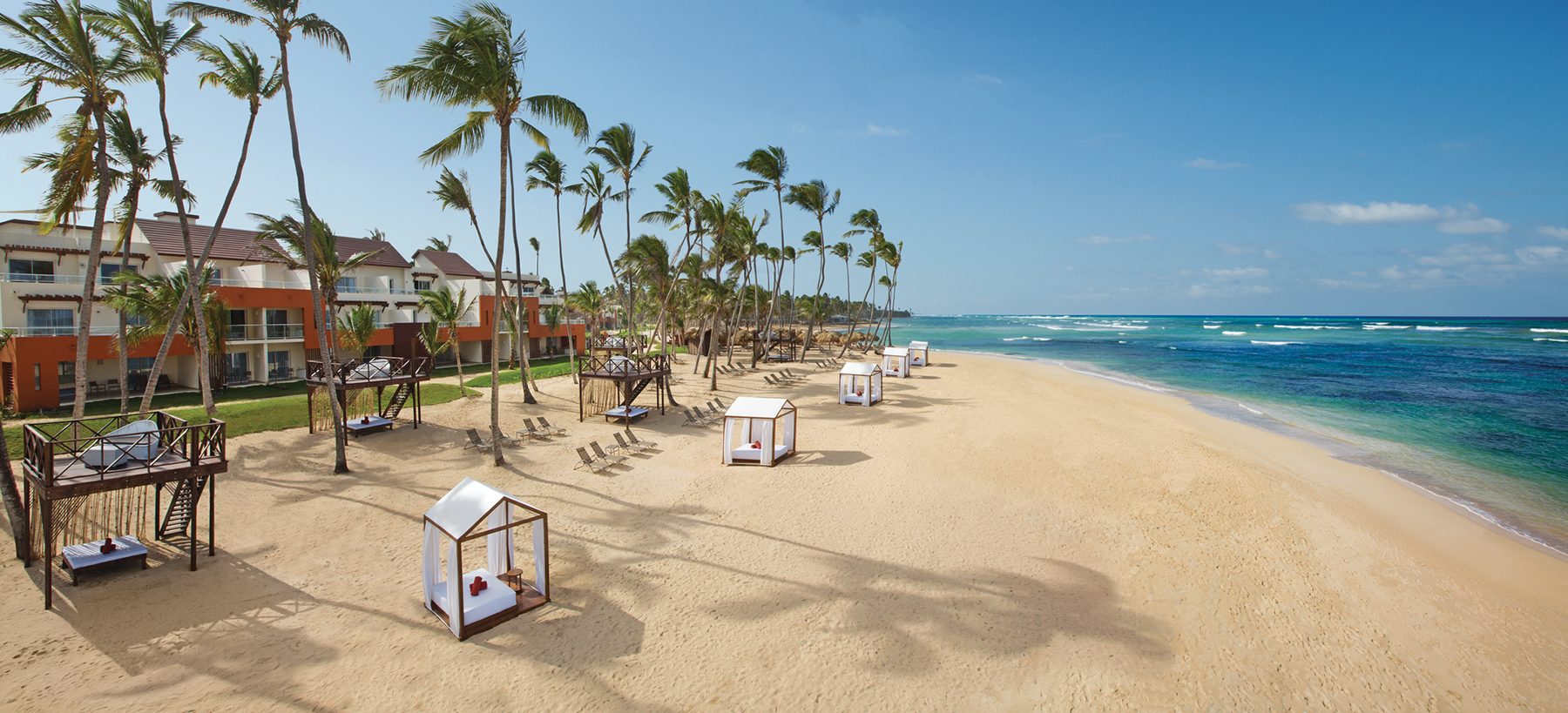 Breathless Punta Cana Resort & Spa Reviews: What Guests Really Say About This Adults-Only All Inclusive 2 An aerial view showcases the stunning Breathless Punta Cana resort, featuring multiple sparkling swimming pools adjacent to a pristine white sand beach and the vibrant turquoise ocean. The expansive resort grounds are designed for relaxation and fun, offering guests a tropical paradise with exceptional service and all-inclusive amenities.