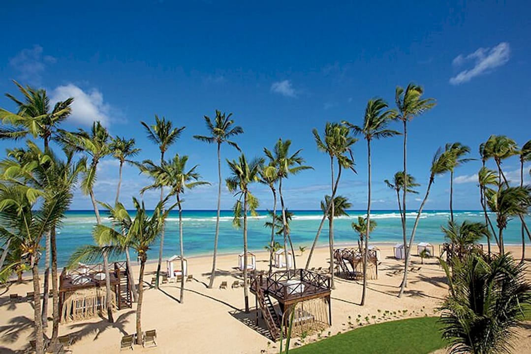 Breathless Punta Cana Resort & Spa Reviews: What Guests Really Say About This Adults-Only All Inclusive 1 A stunning tropical resort features a modern pool area surrounded by lush palm trees and comfortable lounge chairs, all bathed in the warm glow of golden hour. This adults-only all-inclusive resort offers a tranquil atmosphere perfect for relaxation, with exceptional service and beautiful views of the resort grounds.