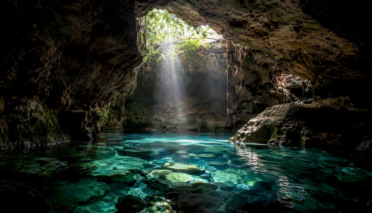 Light beam through partial roof in semi-open cenote